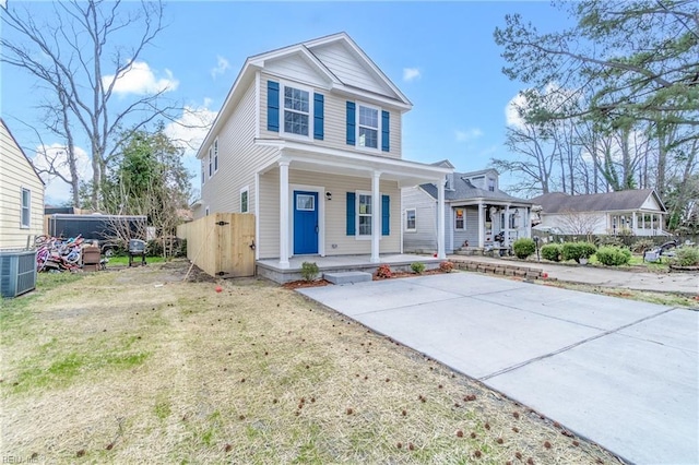 view of front of house with a porch, cooling unit, and a front lawn