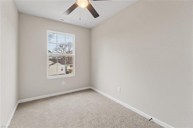 carpeted spare room with visible vents, ceiling fan, and baseboards