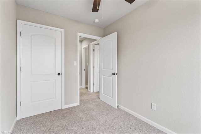 unfurnished bedroom with a ceiling fan, carpet flooring, and baseboards