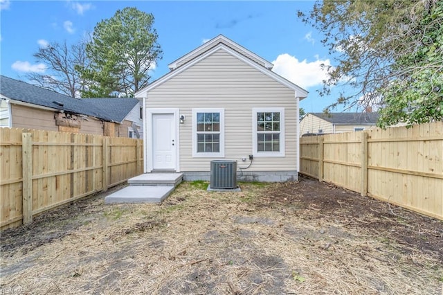 rear view of house featuring central AC unit and a fenced backyard