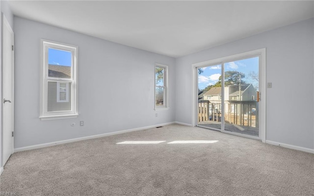 unfurnished room featuring light carpet, visible vents, and baseboards