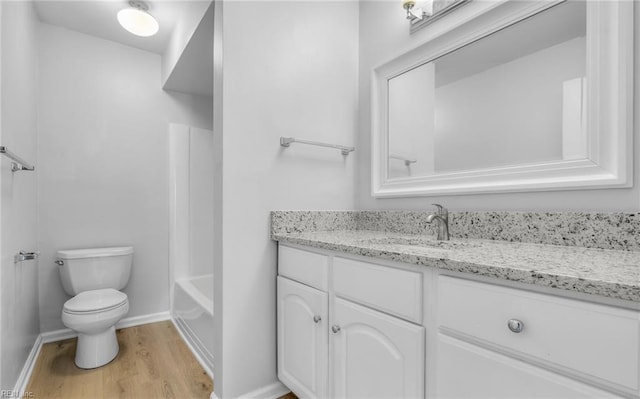 full bath featuring toilet, baseboards, wood finished floors, and vanity