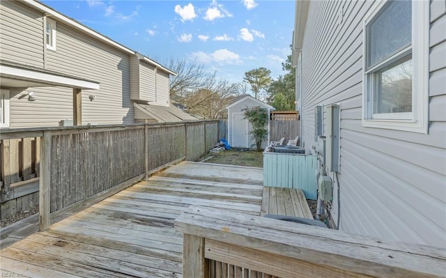 deck with a shed, an outdoor structure, and fence