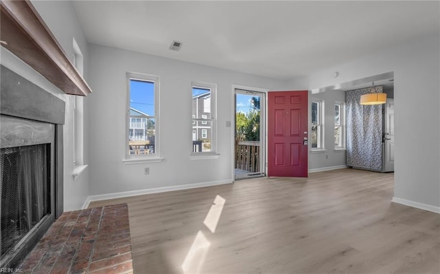 entrance foyer with plenty of natural light, visible vents, wood finished floors, and a high end fireplace