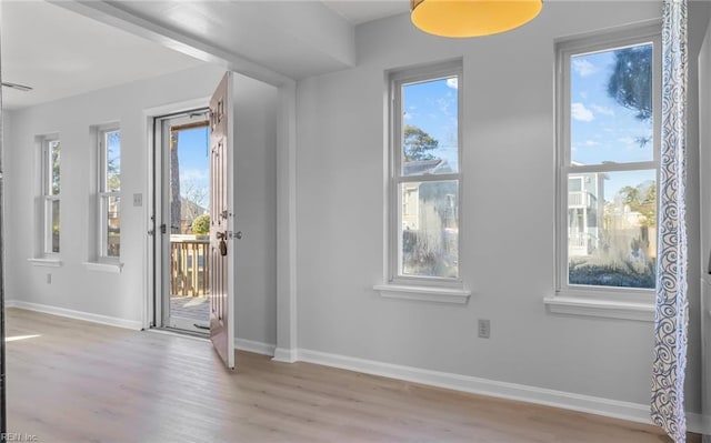 foyer featuring light wood finished floors and baseboards