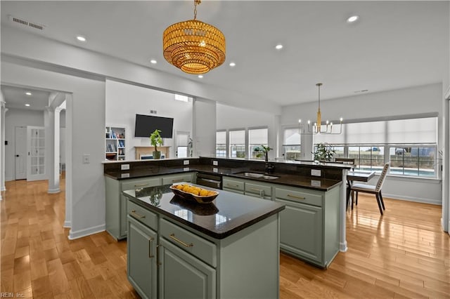 kitchen with a center island, ornate columns, a sink, and green cabinets