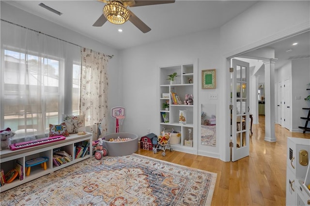 recreation room featuring built in features, decorative columns, recessed lighting, ceiling fan, and wood finished floors