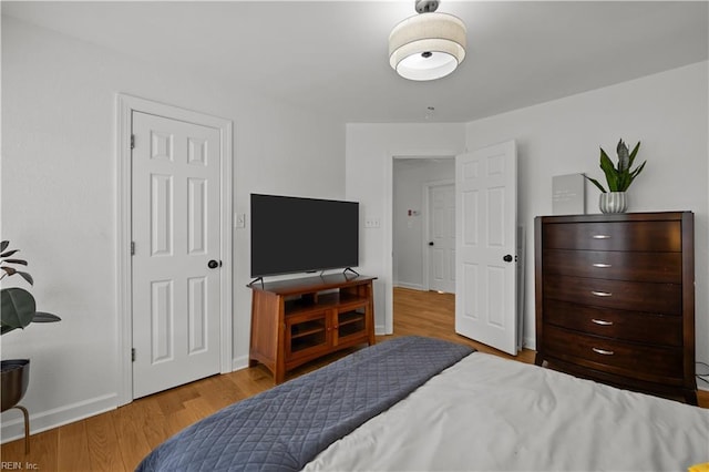 bedroom with baseboards and wood finished floors