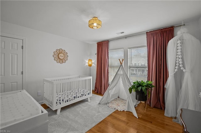 bedroom featuring visible vents and wood finished floors