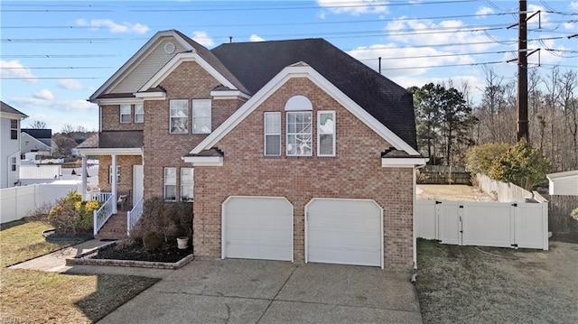 traditional-style house with driveway, a garage, fence, and brick siding