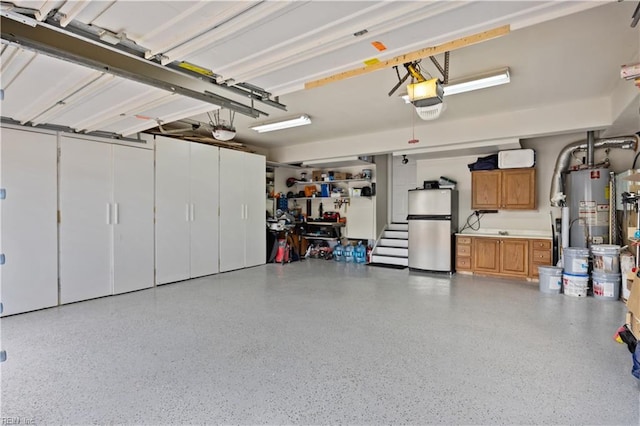 garage with a garage door opener, freestanding refrigerator, and gas water heater