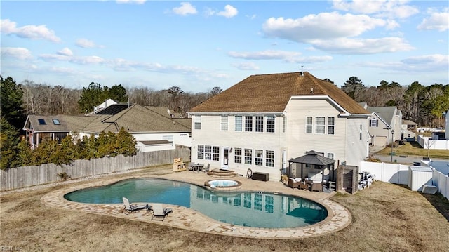 rear view of property with a fenced in pool, a gazebo, a patio area, an in ground hot tub, and a fenced backyard