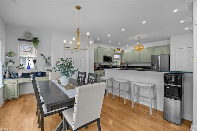 dining area with recessed lighting, an inviting chandelier, and light wood-style floors