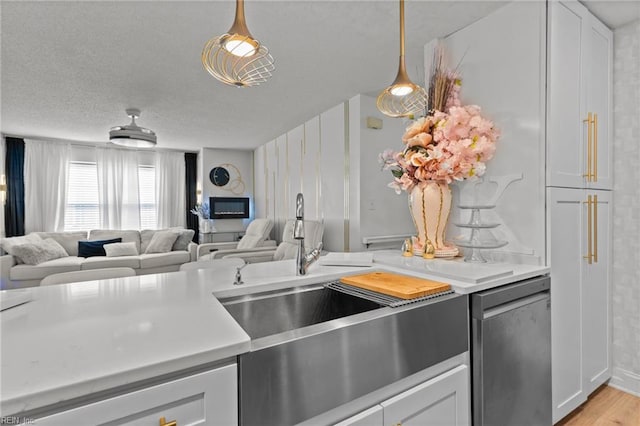 kitchen with light wood finished floors, open floor plan, white cabinets, and light countertops