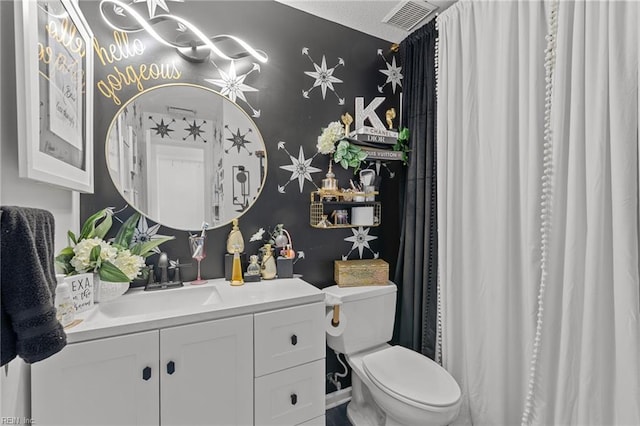 bathroom with visible vents, toilet, and vanity