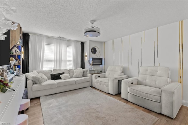 living room with light wood-style floors and a textured ceiling