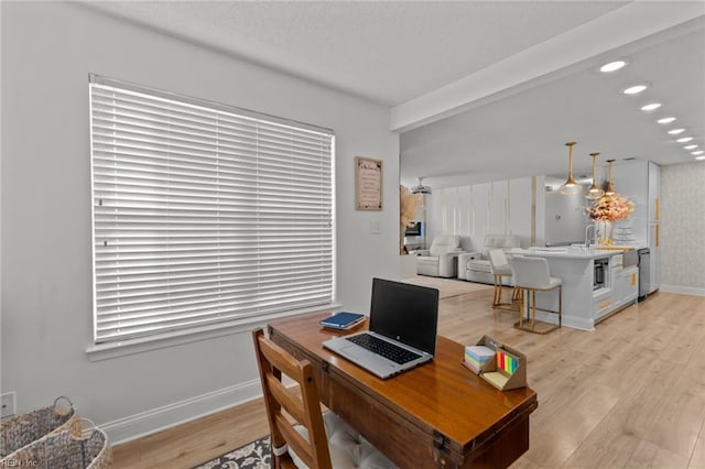 home office featuring recessed lighting, baseboards, light wood-style floors, and a sink