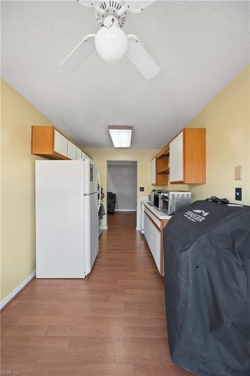 kitchen with open shelves, freestanding refrigerator, ceiling fan, wood finished floors, and baseboards