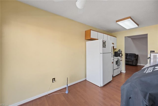 kitchen featuring white appliances, ceiling fan, baseboards, and wood finished floors