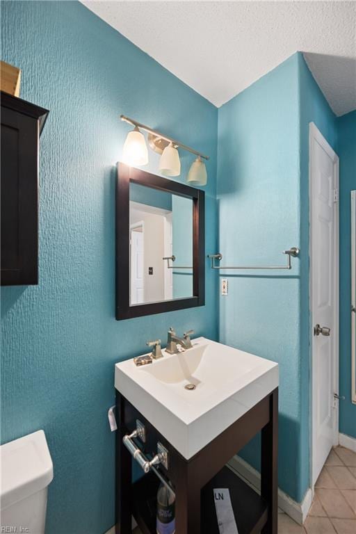 bathroom featuring vanity, tile patterned flooring, and toilet