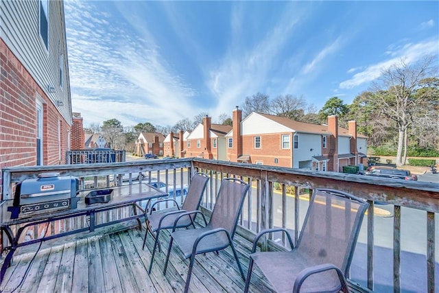 deck featuring a residential view and a grill