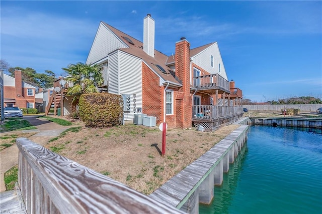 view of home's exterior featuring stairs, a water view, and cooling unit