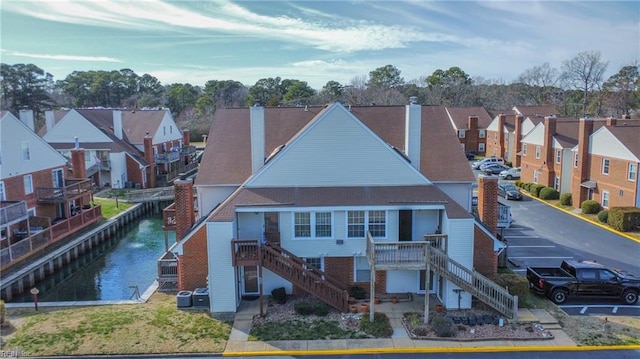 birds eye view of property with a water view and a residential view