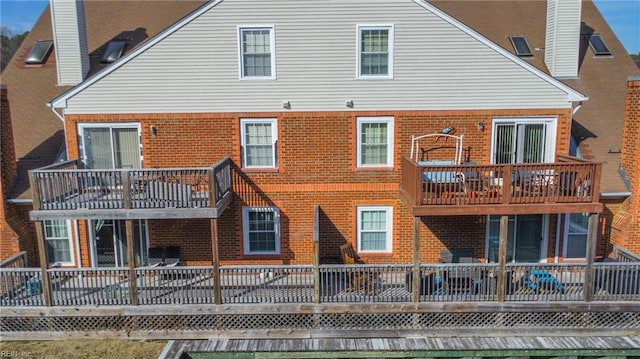 rear view of house with brick siding and a balcony