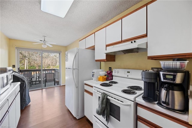 kitchen featuring light countertops, dark wood-type flooring, white cabinetry, white appliances, and under cabinet range hood