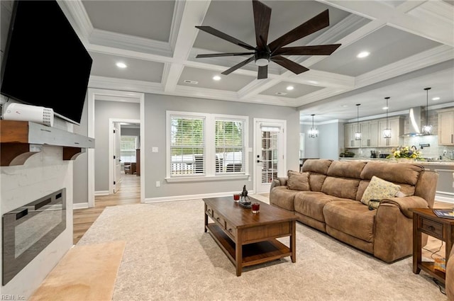 living area featuring beam ceiling, recessed lighting, ornamental molding, a high end fireplace, and coffered ceiling