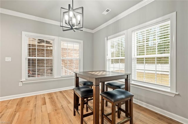 dining space featuring a chandelier, plenty of natural light, visible vents, and crown molding