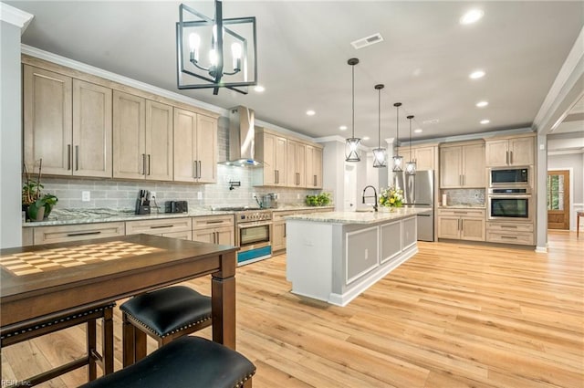 kitchen featuring light wood finished floors, stainless steel appliances, wall chimney range hood, and crown molding
