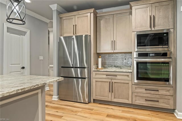 kitchen featuring ornamental molding, appliances with stainless steel finishes, backsplash, light stone countertops, and light wood finished floors