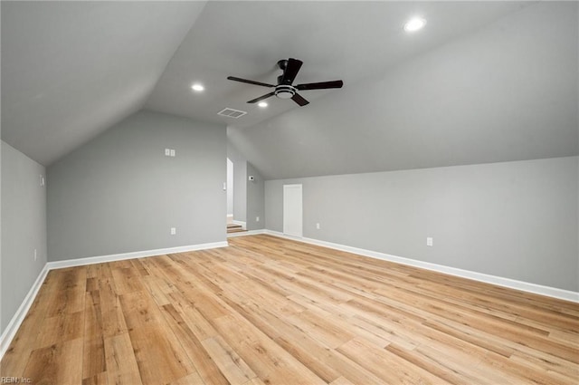 additional living space featuring lofted ceiling, visible vents, light wood-style floors, ceiling fan, and baseboards