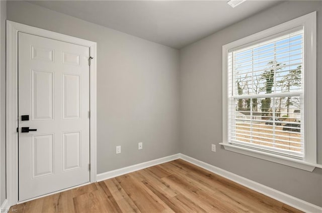 spare room with light wood-type flooring and baseboards