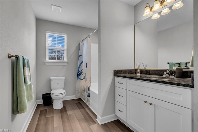 full bath with toilet, shower / bath combo with shower curtain, vanity, wood finished floors, and baseboards