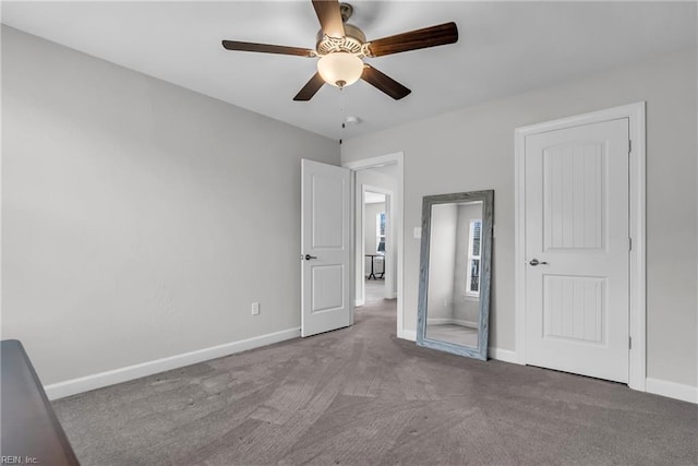 unfurnished bedroom featuring carpet floors, a ceiling fan, and baseboards