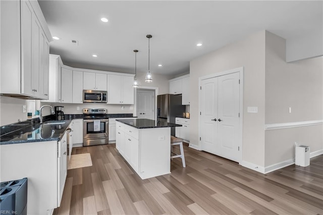 kitchen featuring white cabinets, stainless steel appliances, and wood finished floors