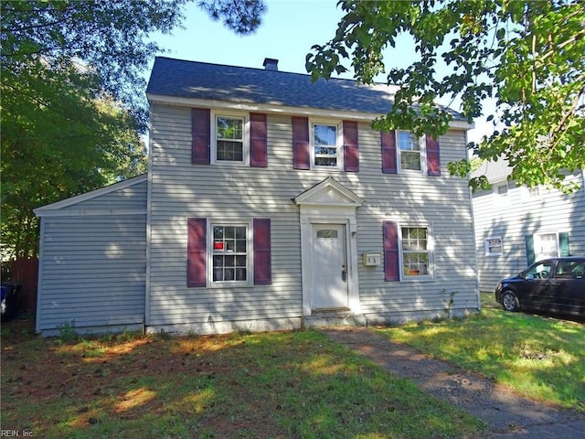 colonial house with a chimney and a front lawn