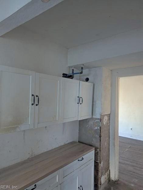 interior space with butcher block counters and white cabinets