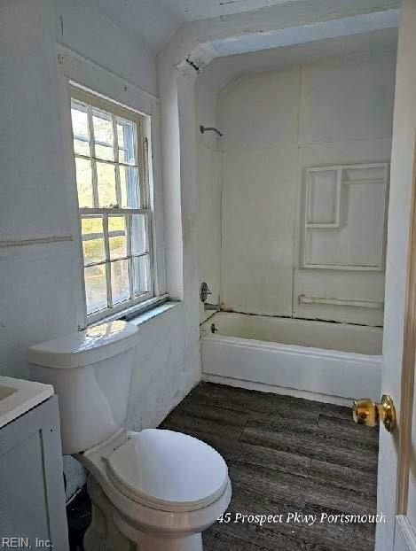 full bathroom featuring wood finished floors, shower / bath combination, vanity, and toilet