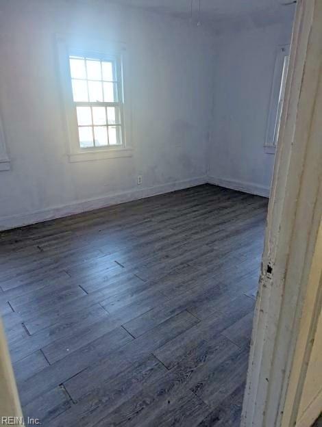 empty room featuring baseboards and wood finished floors