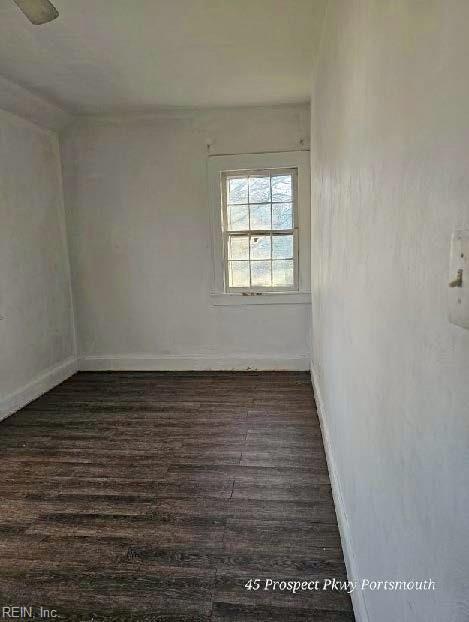 unfurnished room with dark wood-style floors and baseboards