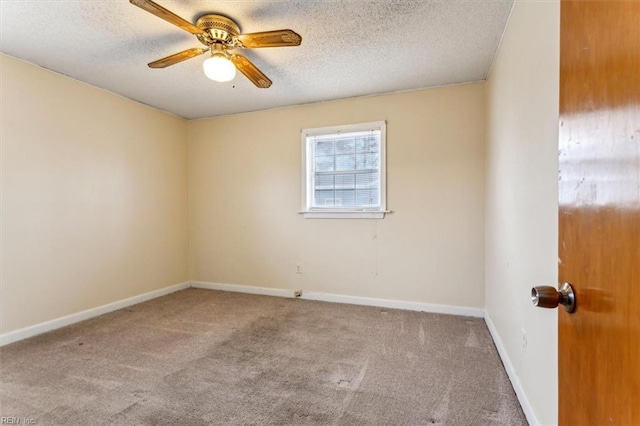 carpeted spare room with ceiling fan, a textured ceiling, and baseboards