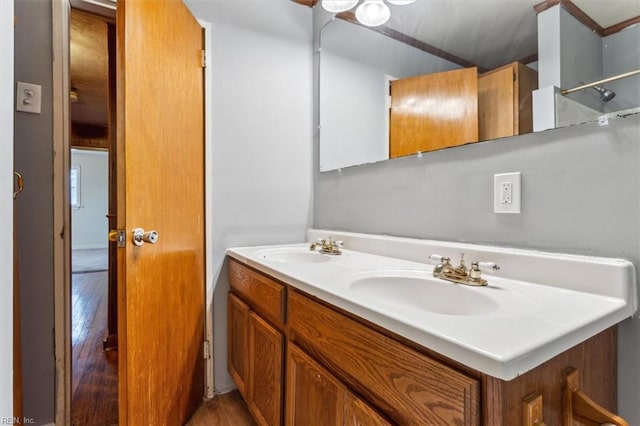 full bathroom featuring double vanity, a sink, and wood finished floors