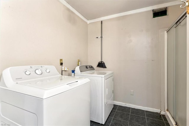 laundry room with laundry area, dark tile patterned flooring, baseboards, washer and clothes dryer, and crown molding