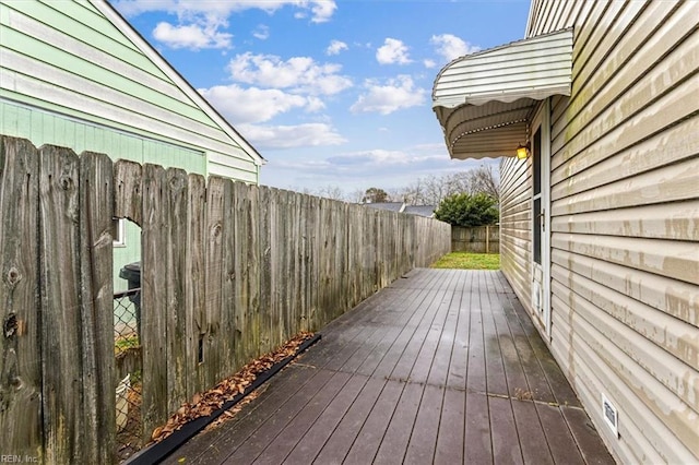 wooden terrace with a fenced backyard