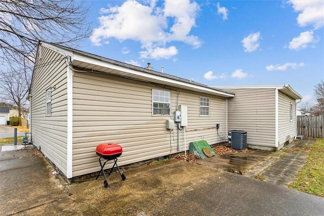 view of home's exterior with central AC and fence