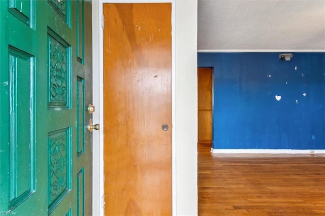 interior space with a textured ceiling, wood finished floors, and baseboards