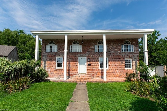 view of front of property featuring brick siding and a front yard